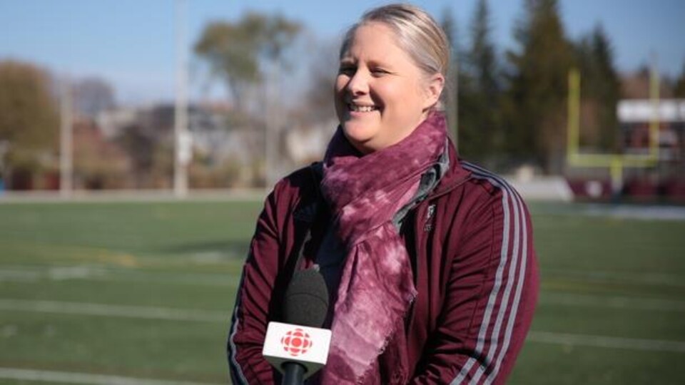 Une femme donne une entrevue à Radio-Canada sur un terrain de soccer.