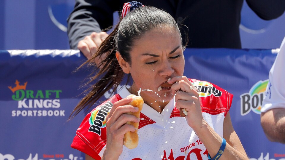 Une participante mange un hot dog avec vigueur lors d'un concours à New York. 