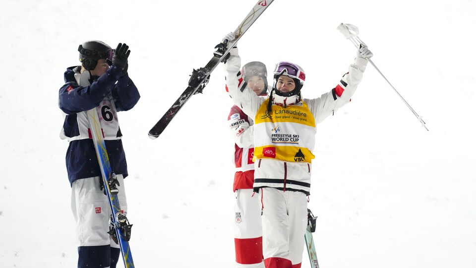 Un skieur lève les bras au ciel après avoir remporté une course.