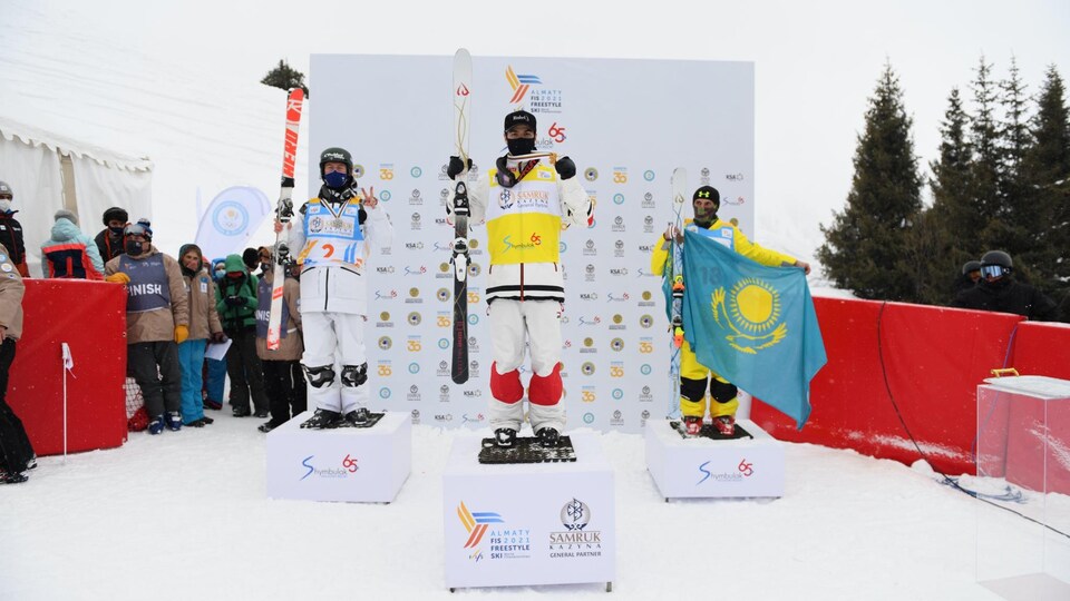 Trois skieurs sont sur un podium.