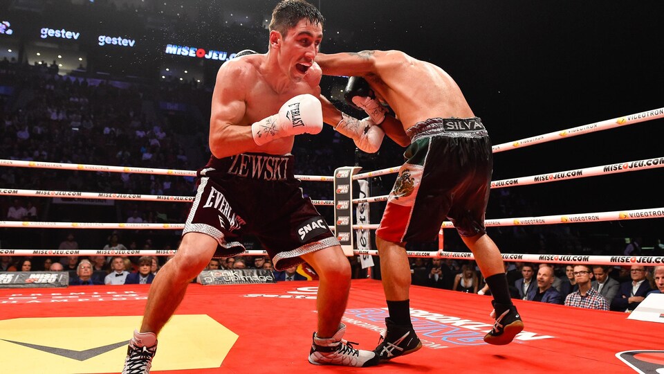Sur le ring, en combat, il lance un crochet de gauche au corps de son adversaire.