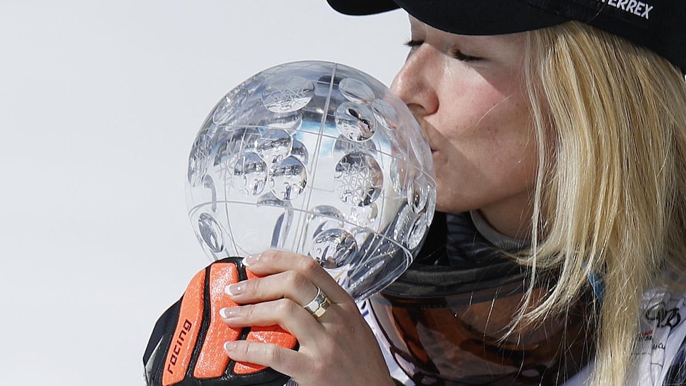 Une femme embrasse un globe de cristal.