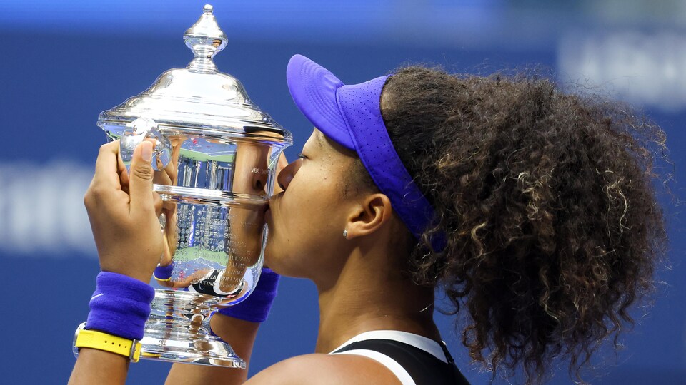 Elle embrasse le trophée remis à la championne des Internationaux des États-Unis.