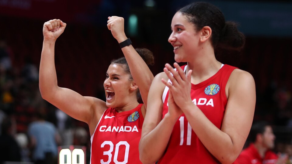 Deux basketteuses canadiennes célèbrent une victoire.
