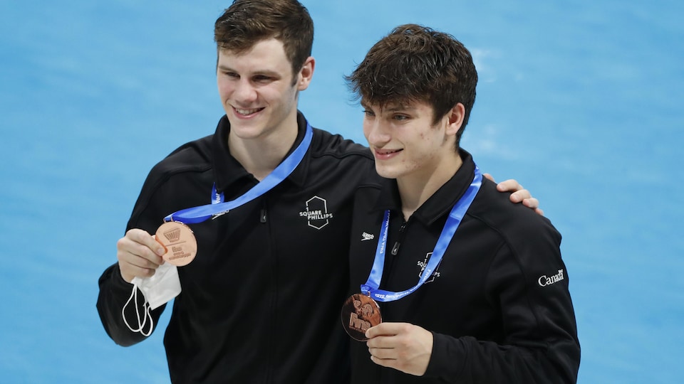 Los dos jóvenes posan con las medallas colgando del cuello.