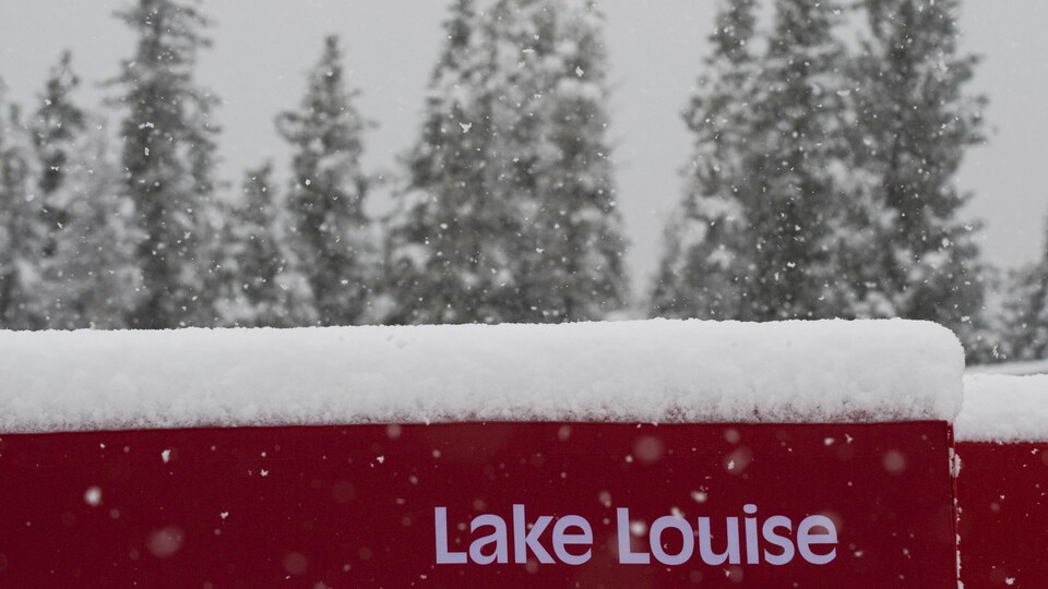 Elle s'accumule sur un muret rouge où il est écrit Lake Louise.
