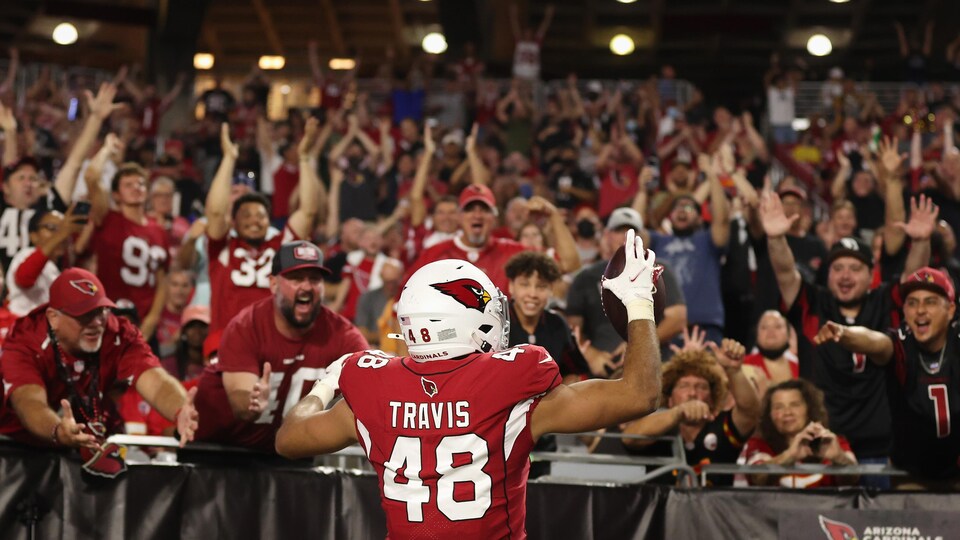Un joueur de football des Cardinals est acclamé par une foule lors d'un match.