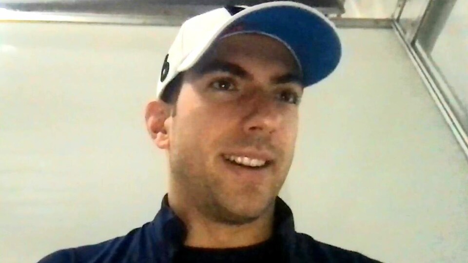 Un pilote de F1 avec une casquette sur la tête donne une entrevue à distance. 