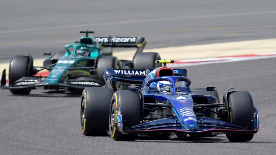 Deux voitures se suivent sur un circuit de F1.