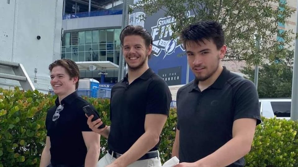 Cole Caufield, Jesperi Kotkaniemi et Nick Suzuki marchent ensemble près de l'Amalie Arena, à Tampa Bay.