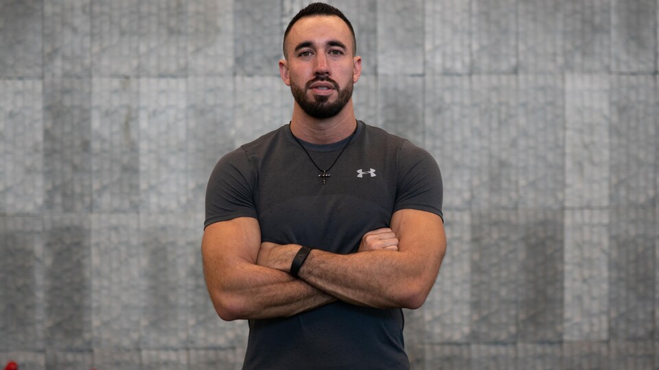 Un homme pose dans un gymnase d'entraînement.