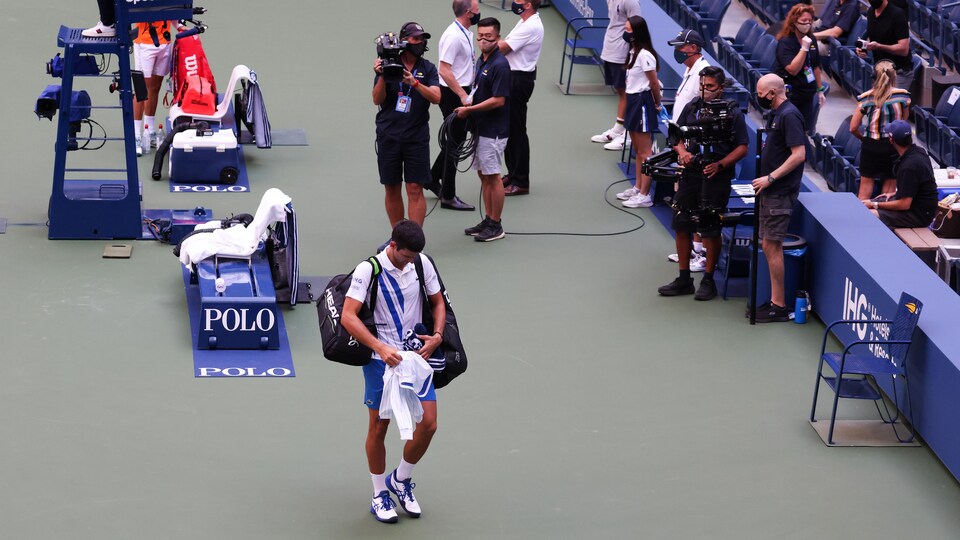 Novak Djokovic quitte le terrain après avoir été disqualifié.