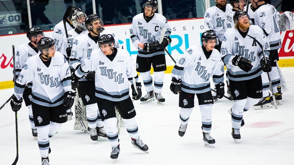 Des joueurs de hockey quittent la patinoire après un match.