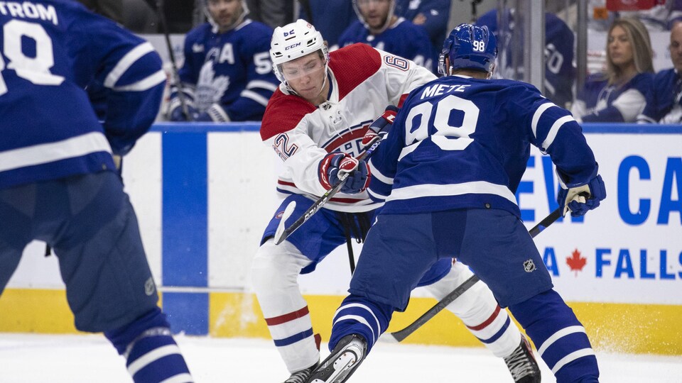 Owen Beck , le nuéro 6e des Canadiens de Montréal, lance la rondelle derrière un joueur des Maple Leafs.
