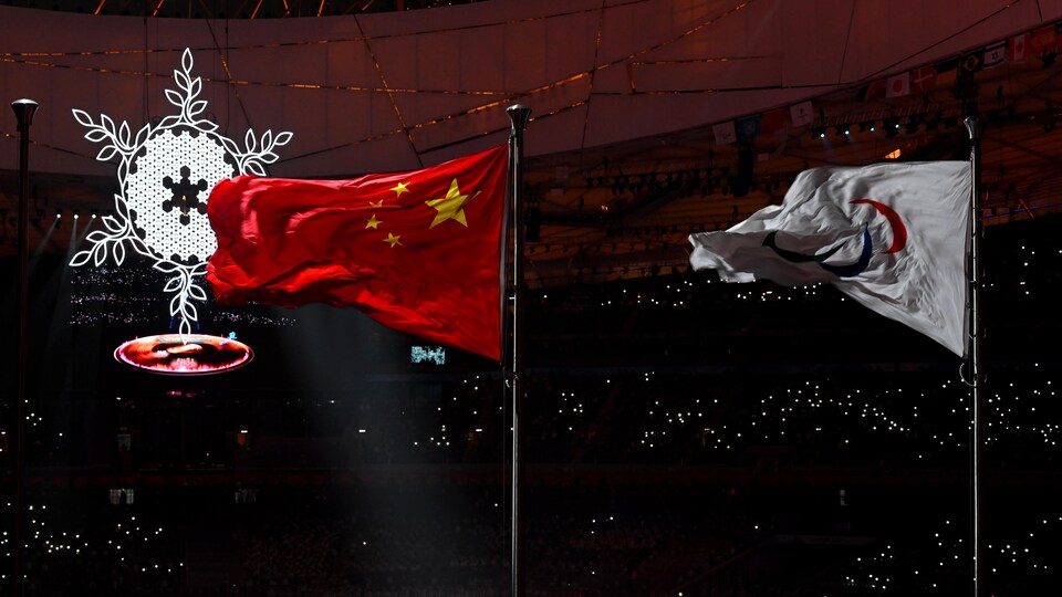 Deux drapeaux flottent au dessus du stade, devant un immense flocon. 