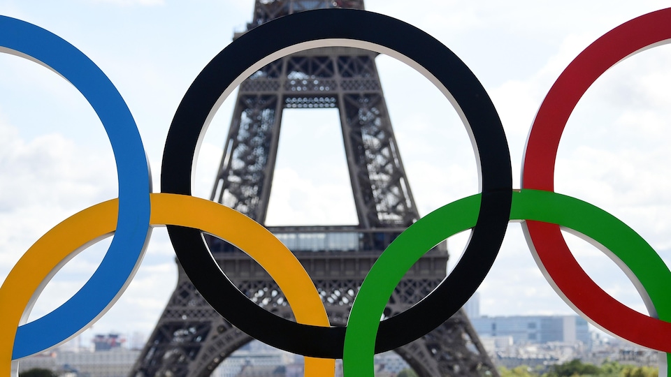 La tour Eiffel vue à travers les anneaux olympiques.