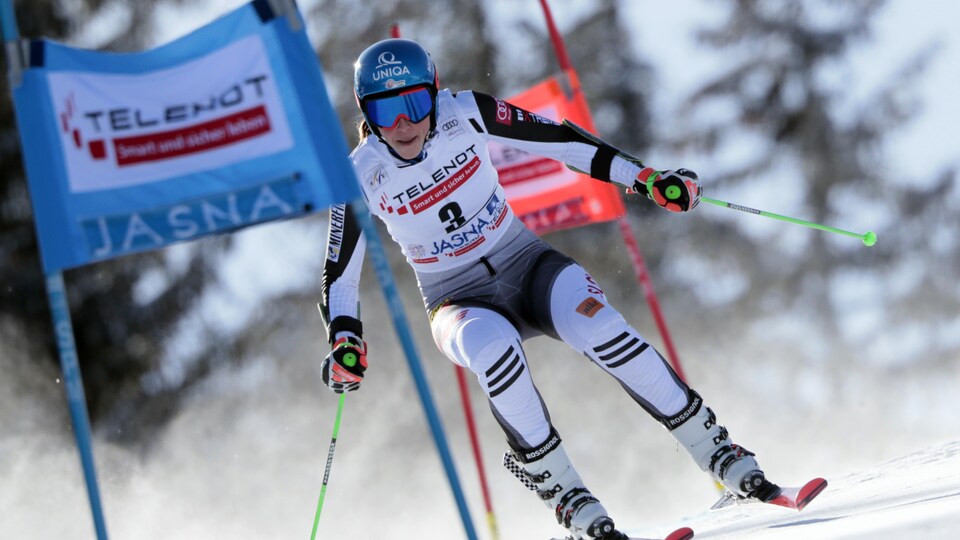 Un skieuse entre deux portes lors d'une descente