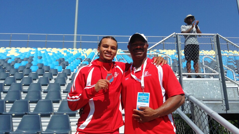 Tony Sharpe et Andre De Grasse, côte à côte dans les gradins d'un stade