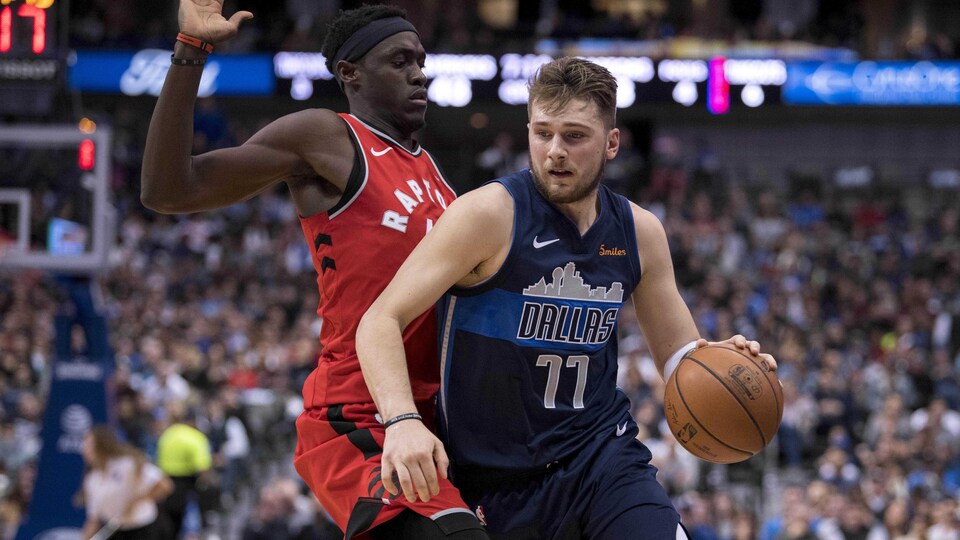 L'ailier recrue Luka Doncic des Mavericks de Dallas tente de passer Pascal Siakam des Raptors de Toronto.