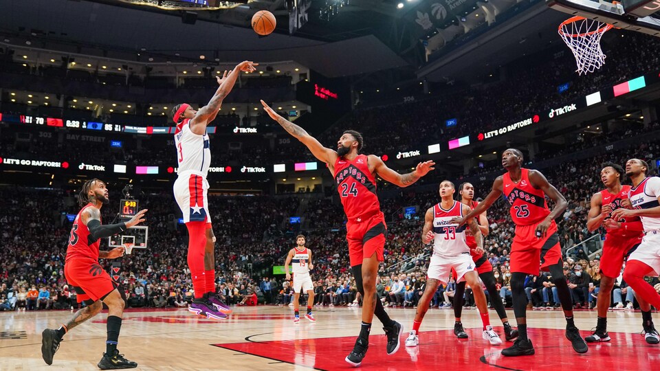 Bradley Beal tente un lancer sous le regard de plusieurs joueurs des Raptors.