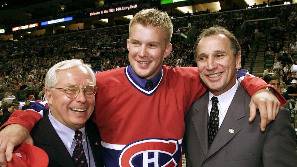 Three men pose for the photo.