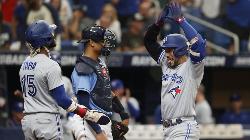 Deux joueurs de baseball célèbrent un circuit au marbre.
