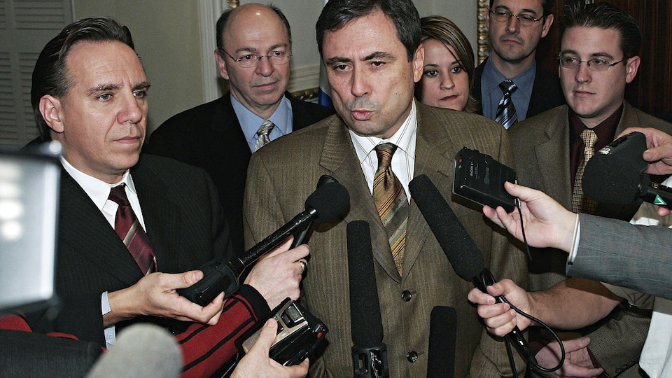Entouré de collègues du Parti québécois, Richard Legendre répond à des questions des journalistes. 