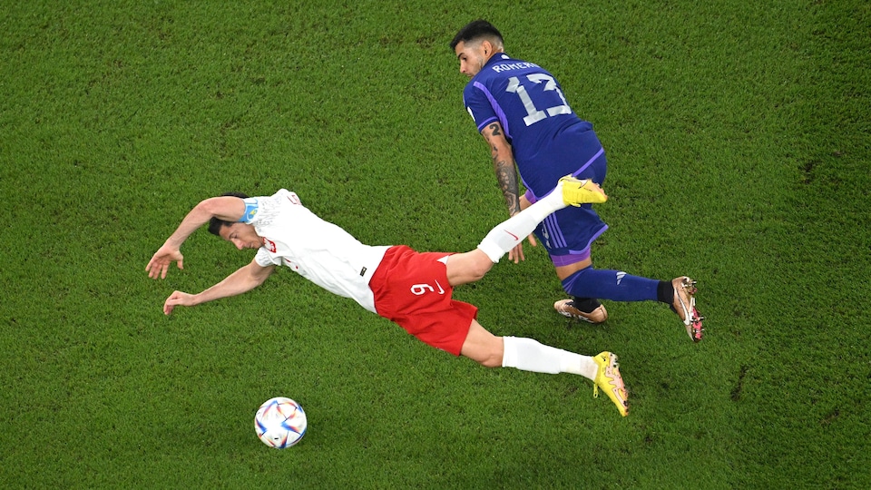 Un joueur de soccer chute devant son adversaire. 