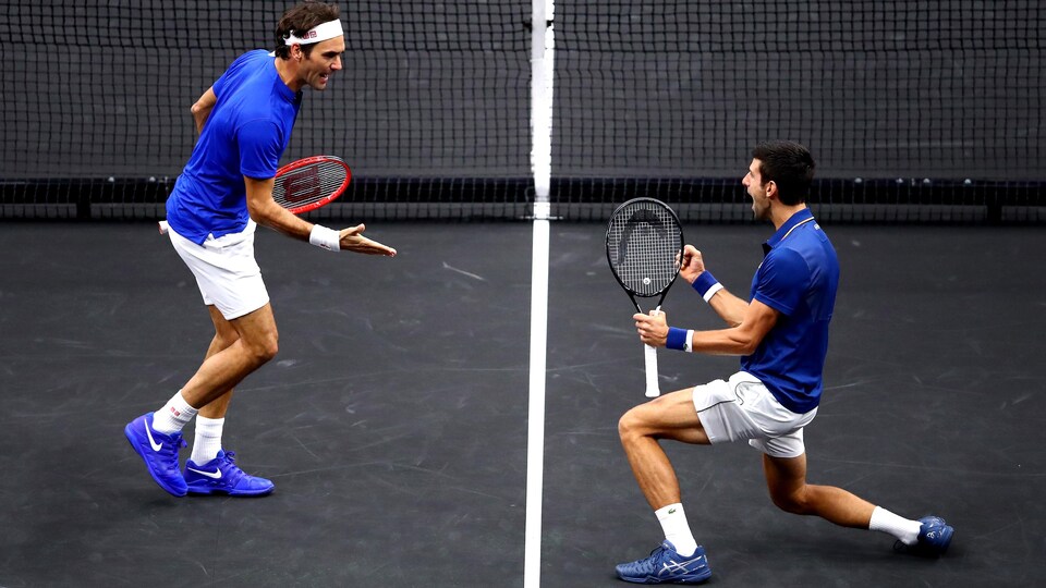 Deux joueurs de tennis se motivent sur un terrain en criant. 