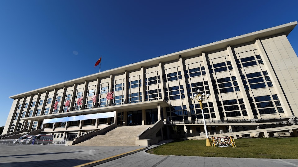 Un grand &eacute;difice de couleur beige muni de nombreuses fen&ecirc;tres.