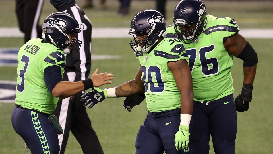 Trois joueurs de football se félicitent.