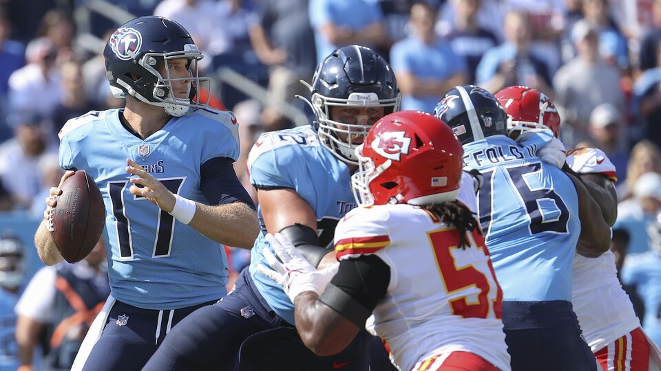 Protégé par sa ligne offensive, il s'apprête a décocher une passe face aux Chiefs.