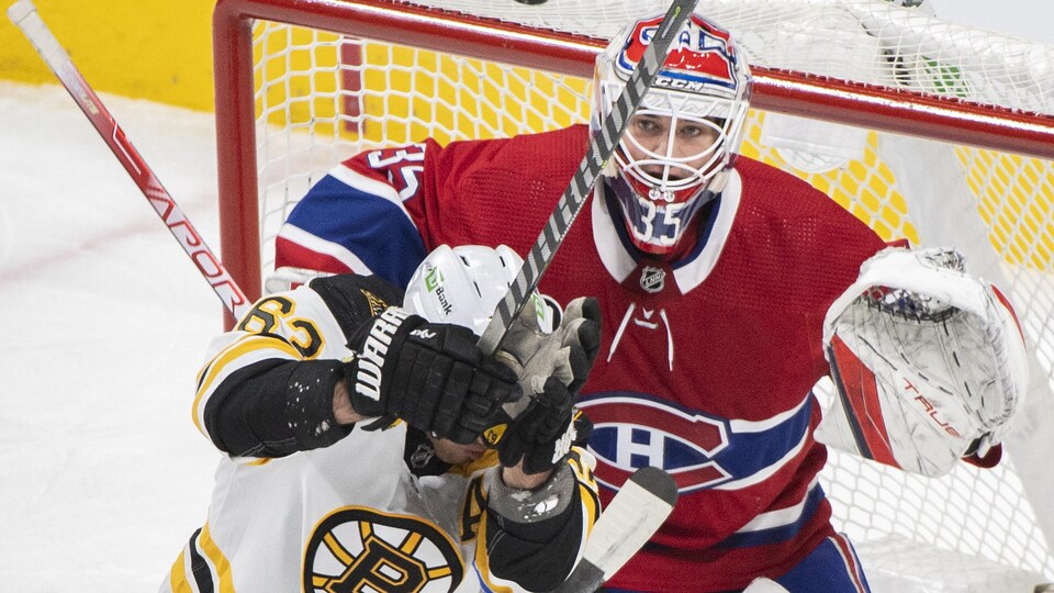 Gêné par un joueur des Bruins, il cherche à garder les yeux sur la rondelle. 