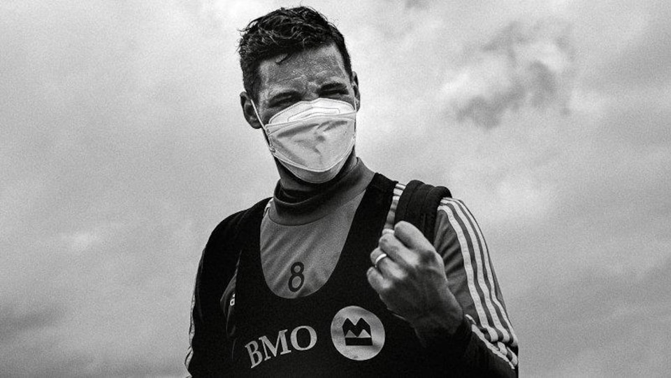Muni d'un masque, il montre le poing.