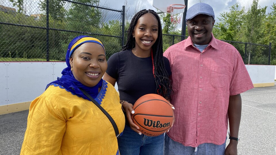 Une joueuse de basketball pose avec ses parents.
