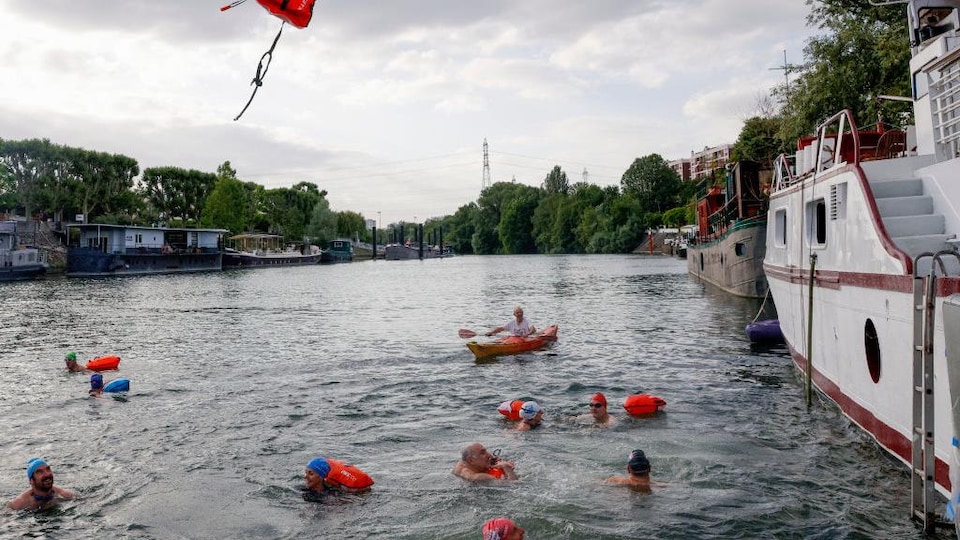 Des nageurs se baignent dans la Seine. 
