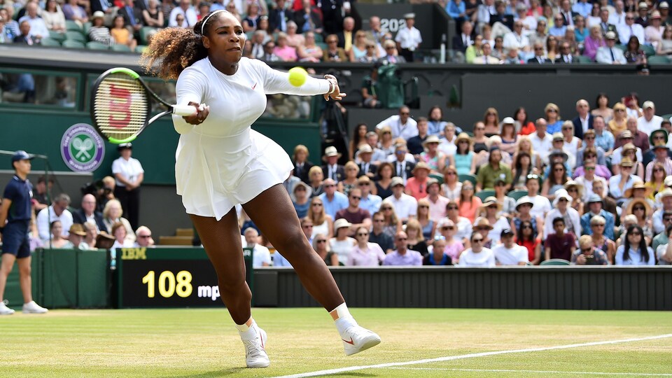 Elle frappe la balle d'un coup droit à Wimbledon.  