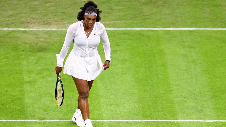 La joueuse de tennis marche sur le terrain en gazon de Wimbledon.