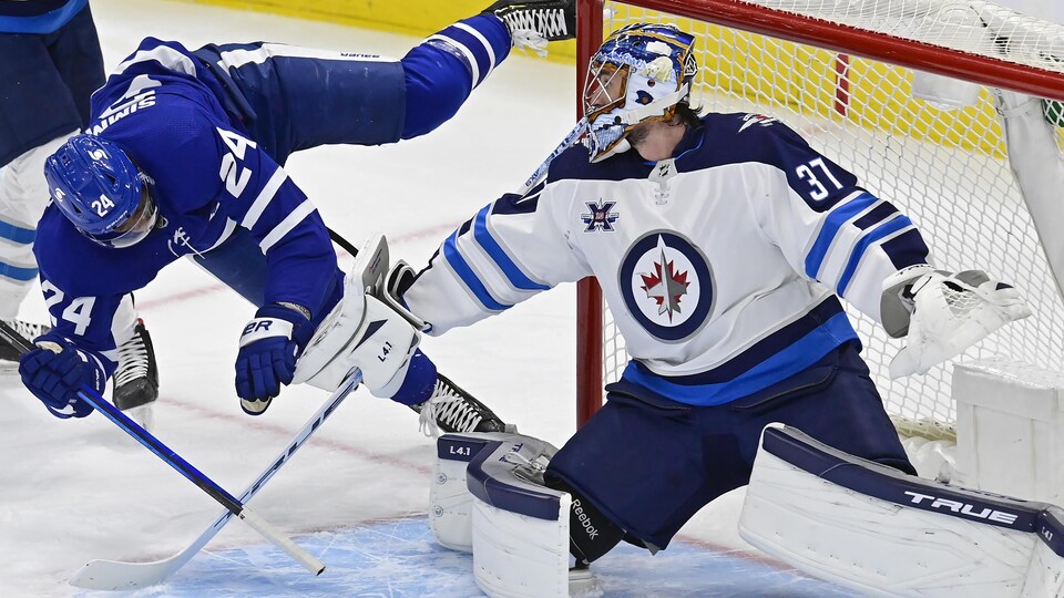 Il trébuche et perd pied après être entré en contact avec le gardien des Jets Connor Hellebuyck.
