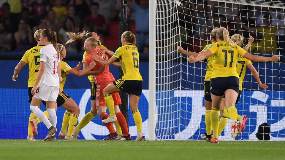 Elles célèbrent leur victoire, tandis que la Canadienne Jeanine Beckie, l'air déçu, marche.