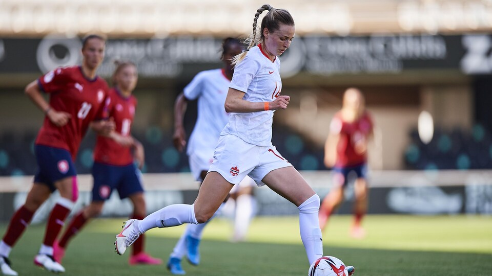 La joueuse canadienne dribble le ballon sur le terrain.