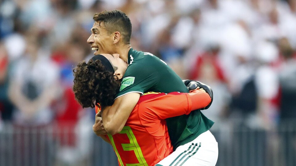 Le Mexicain Hector Moreno (à droite) saute dans les bras de son gardien Guillermo Ochoa après leur victoire contre les Allemands.
