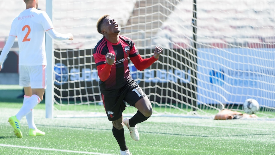 Un joueur célèbre le but qu'il vient de marquer sur un terrain de soccer
