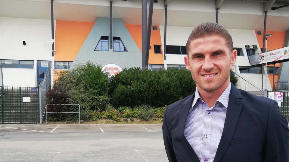 Il prend la pose devant l'amphithéâtre de son club.