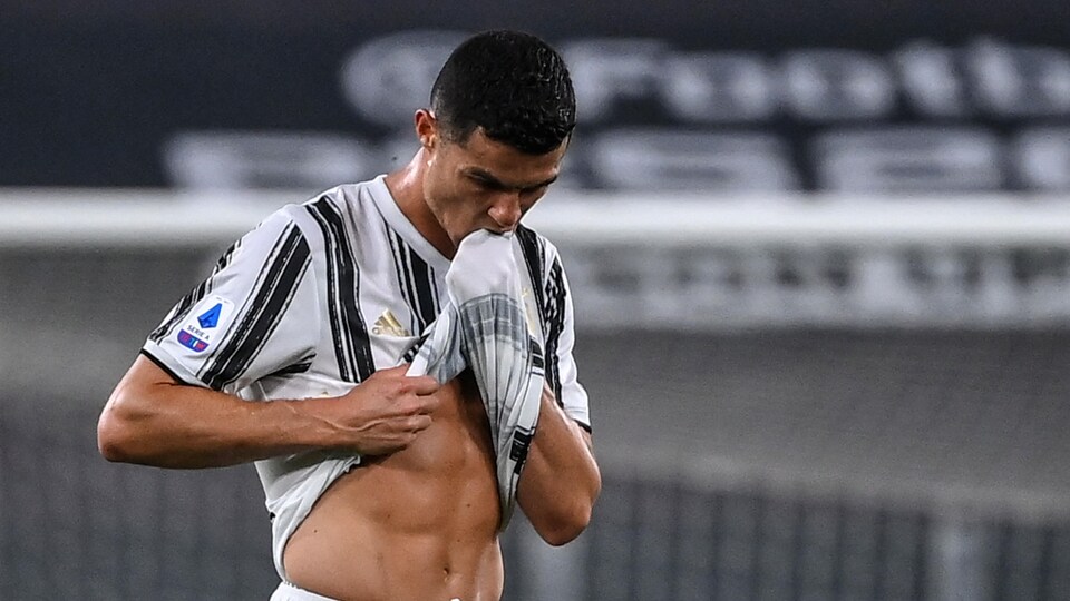 Il porte sa main entourée du tissu de son maillot à sa bouche.