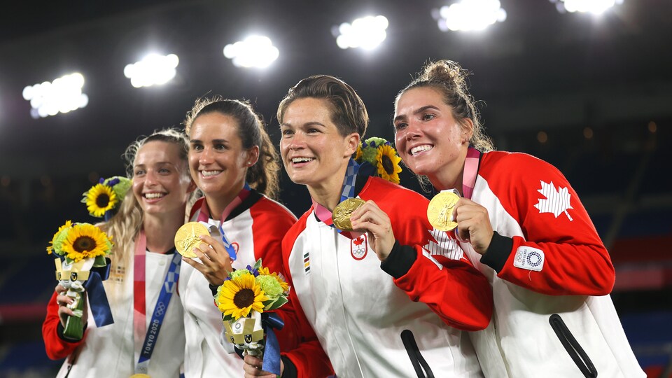 Avec deux coéquipières, elles montrent leur médaille d'or.