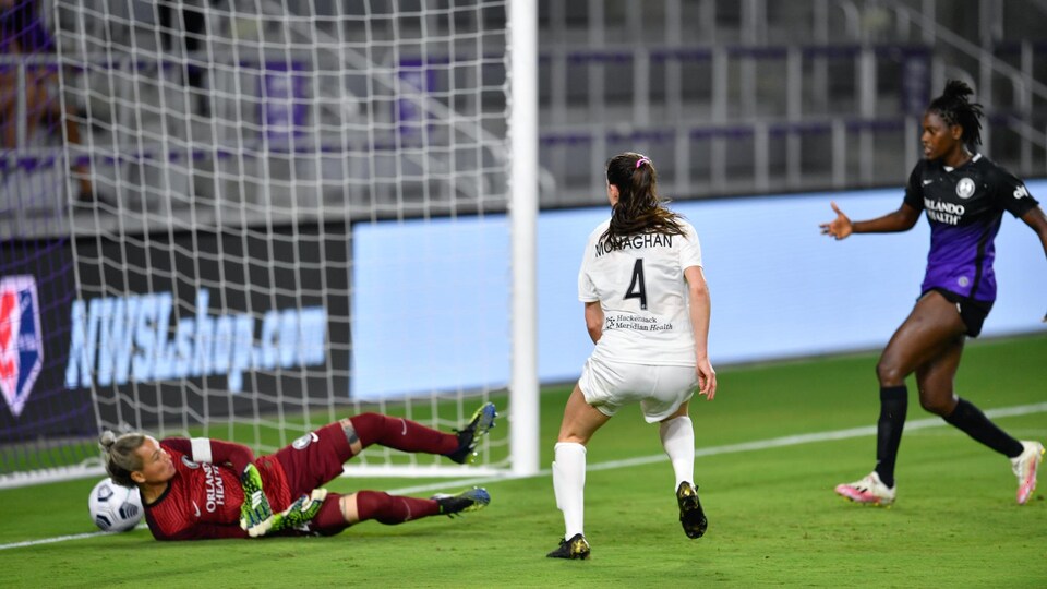 Elle regarde le ballon glisser derrière la ligne des buts.