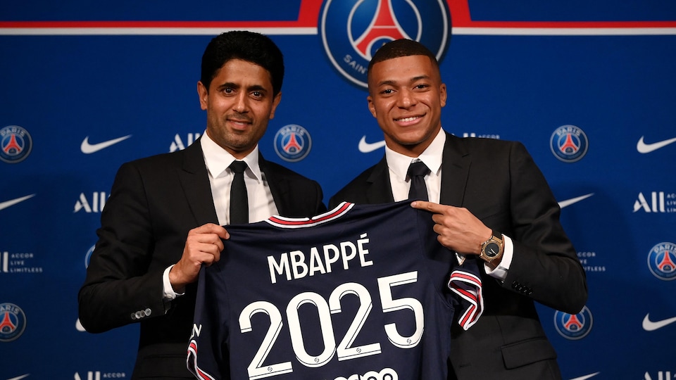 Two men holding soccer jerseys with the inscription Mbappé 2025.