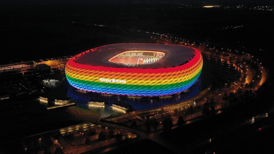 Un stade illuminé aux couleurs de l'arc-en-ciel.