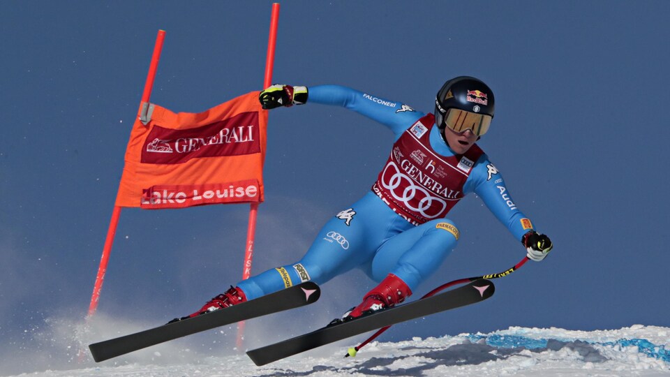 Une skieuse tente de garder son équilibre en dévalant une pente. 